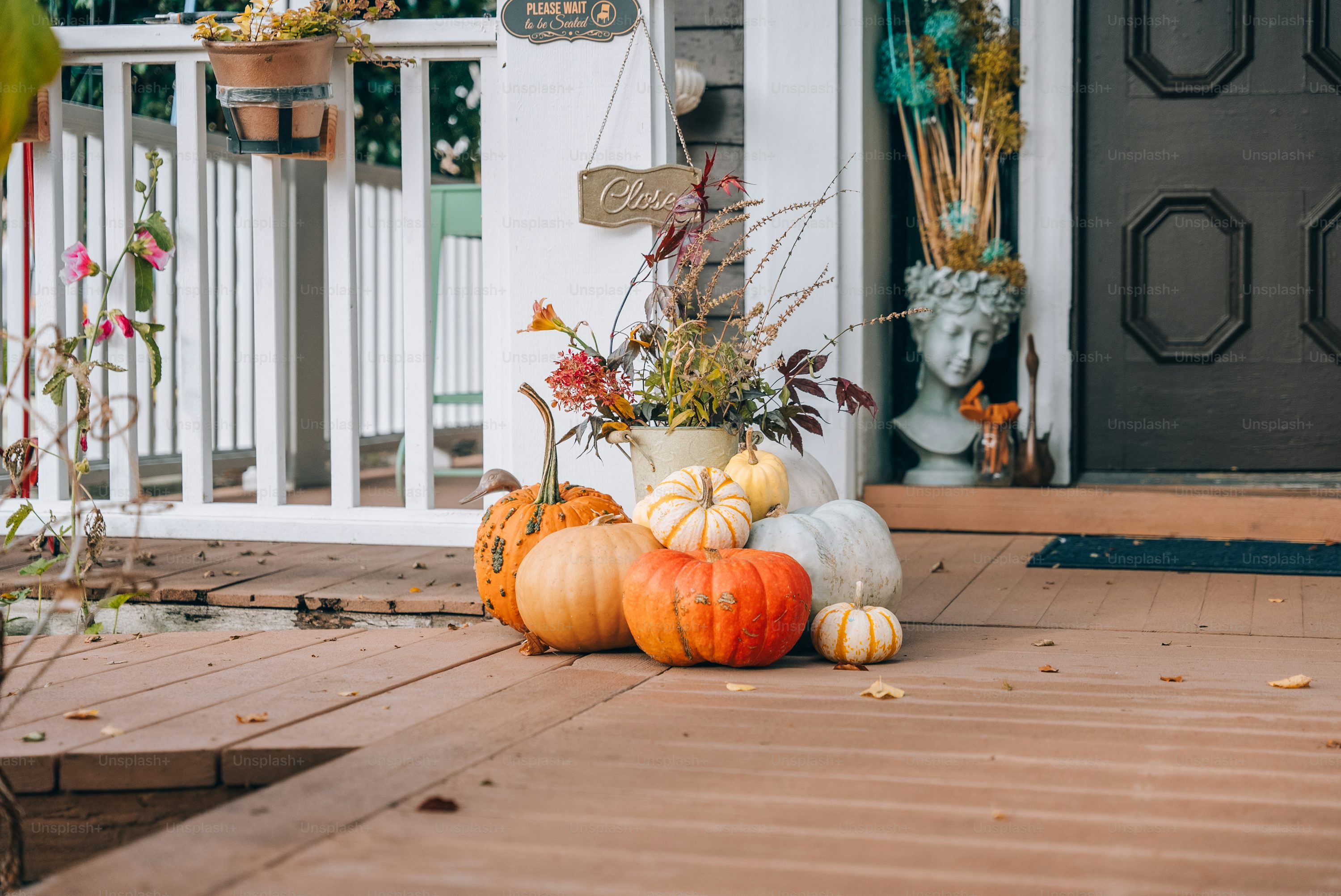 A neutral front porch display with whole pumpkins and gourds